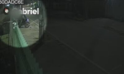 Visão noturna de câmera de segurança mostra homem em moto à noite, texto 'A80DADC6E', 'abriel'
