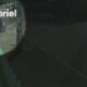 Visão noturna de câmera de segurança mostra homem em moto à noite, texto 'A80DADC6E', 'abriel'