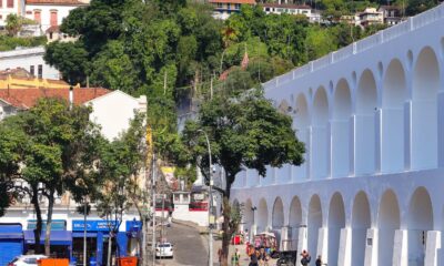 Arcos da Lapa brancos e limpos, com rua movimentada e prédios no Rio de Janeiro