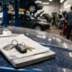 Clipboard com ordem de serviço e chaves de carro sobre capô azul em oficina mecânica