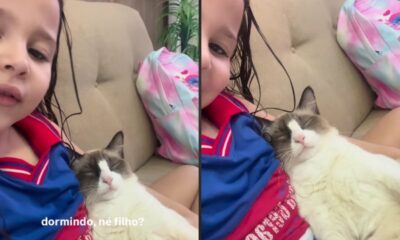 Menina com cabelo molhado e gato dormindo no colo, com a frase “dormindo, né filho?”