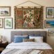 Quarto decorado com cama, tapeçaria tropical, quadros na parede e planta