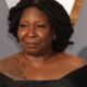 Whoopi Goldberg, dreadlocks, vestido preto, tatuagem, fundo com silhuetas douradas de Oscar