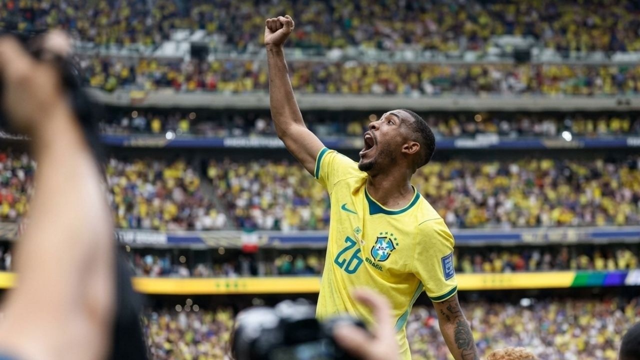 Jogador da seleção brasileira de camisa amarela celebra com braço erguido em estádio lotado.
