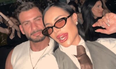 Aline Mineiro e Nizam posam abraçados, ela de óculos escuros e ele de regata branca
