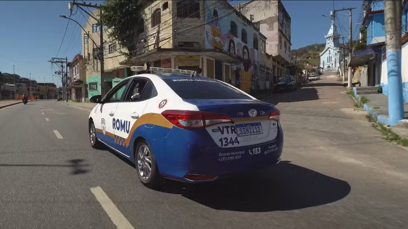 Vista traseira de viatura branca e azul da Guarda Municipal ROMU em rua urbana