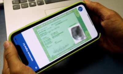 Mãos seguram smartphone exibindo a Carteira de Identidade Nacional digital na tela