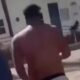Homem sem camisa e de costas corre em ambiente externo, próximo a edifício, imagem desfocada