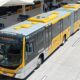 Ônibus articulado BRT cinza e amarelo, "ESPECIAL" E902004, estacionado em terminal