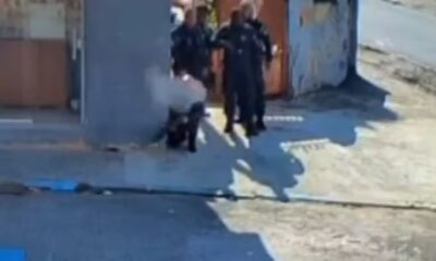 Quatro policiais uniformizados em confronto, um agachado perto de fumaça em Olaria