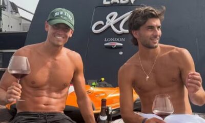 Dois homens sem camisa em barco, segurando taças de vinho, com inscrição "LADY M LONDON"