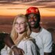 Homem e mulher sorrindo, abraçados, cidade ao pôr do sol, homem com relógios no pulso