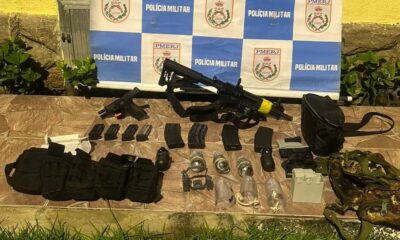 Arsenal com fuzil, pistola, granadas, carregadores e acessórios de drone sobre piso de cerâmica