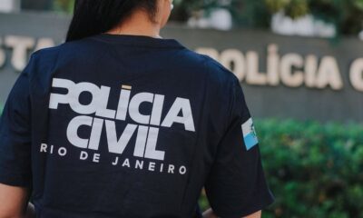 Costas de uma pessoa vestindo camiseta da Polícia Civil do Rio de Janeiro com emblema