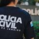 Costas de uma pessoa vestindo camiseta da Polícia Civil do Rio de Janeiro com emblema