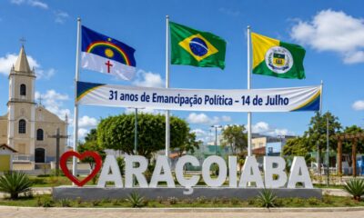 Praça central de Araçoiaba, em Pernambuco, com monumento da cidade, bandeiras do Brasil, de Pernambuco e do município, além de faixa pelos 31 anos de emancipação política em 14 de julho.