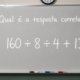 Quadro branco em uma sala de aula com a frase “Qual é a resposta correta?” e a expressão matemática 160 ÷ 8 ÷ 4 + 13 escrita em destaque.