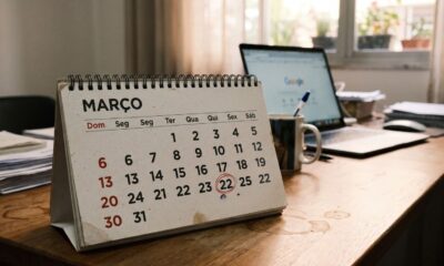 Calendário de mesa Março, dia 22 circulado. Escrivaninha com laptop Google, caneca e mouse