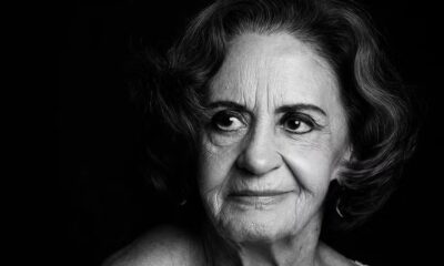 Retrato em preto e branco de uma mulher idosa com cabelo ondulado olhando para o lado
