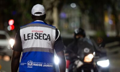 Agente de fiscalização noturna com colete "LEI SECA" e logo do Governo do Rio