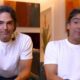Tadeu Schmidt em close com camisa branca e microfone de lapela em ambiente interno