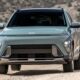 Hyundai SUV verde claro, modelo novo, na estrada de terra sob luz solar