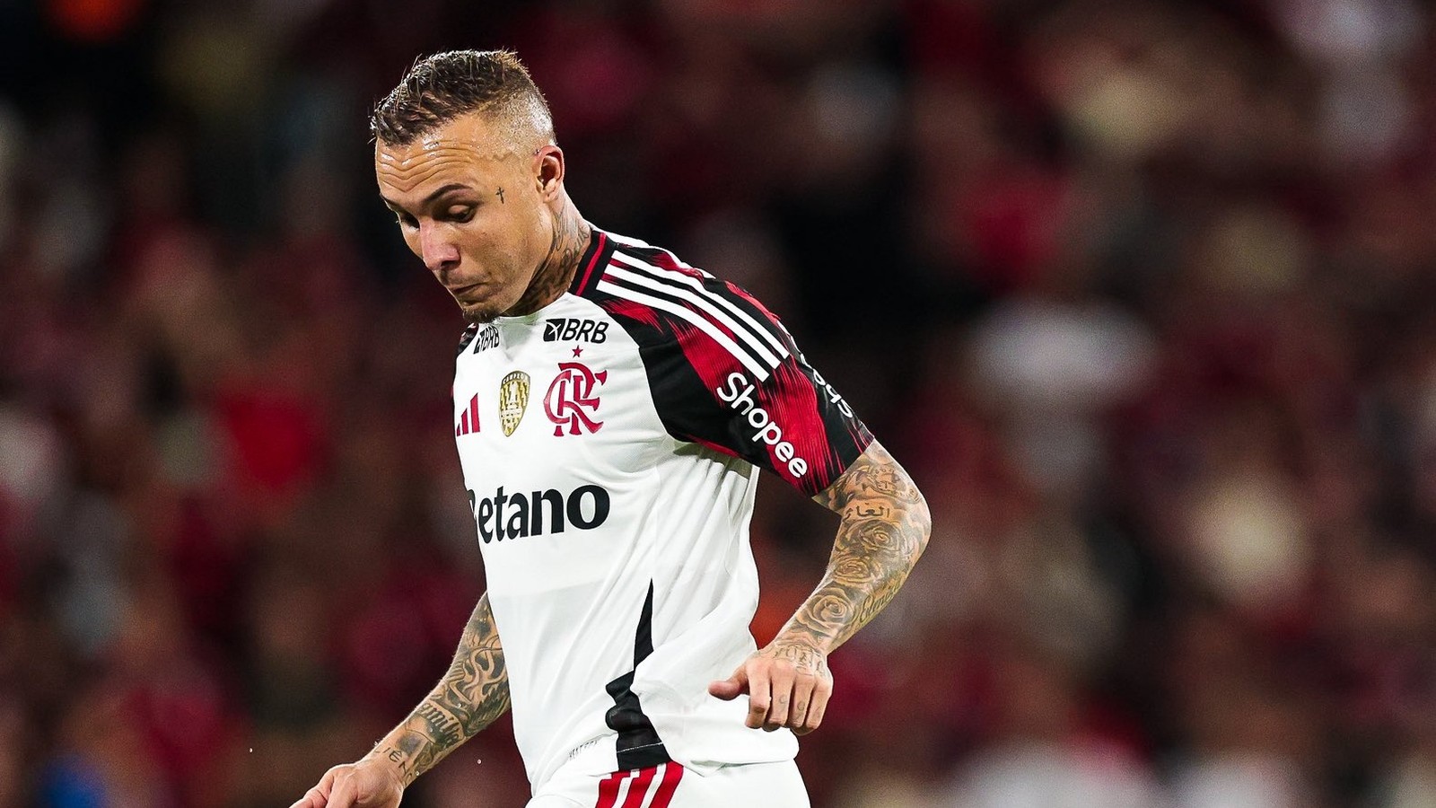 Jogador Everton Cebolinha com camisa do Flamengo, tatuagens, olhando para baixo em campo