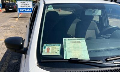 Carteira de motorista e licenciamento de veículo no para-brisa de carro branco