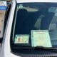 Carteira de motorista e licenciamento de veículo no para-brisa de carro branco