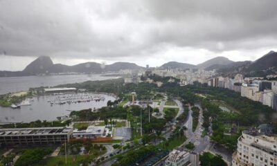 Vista aérea do Rio de Janeiro em dia nublado, com montanhas, marina e edifícios