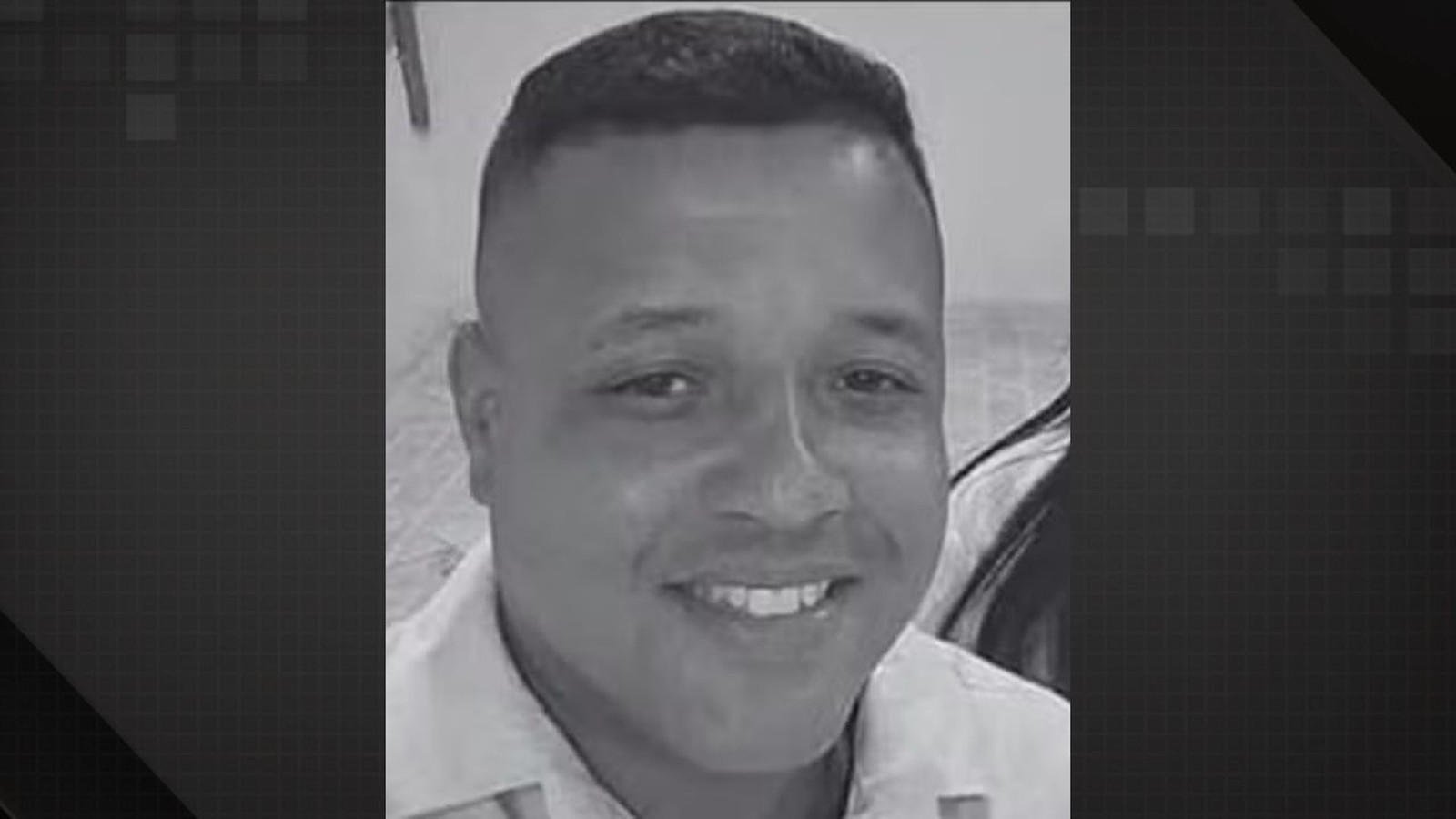 Retrato em preto e branco de um homem sorrindo com cabelo curto e camisa clara