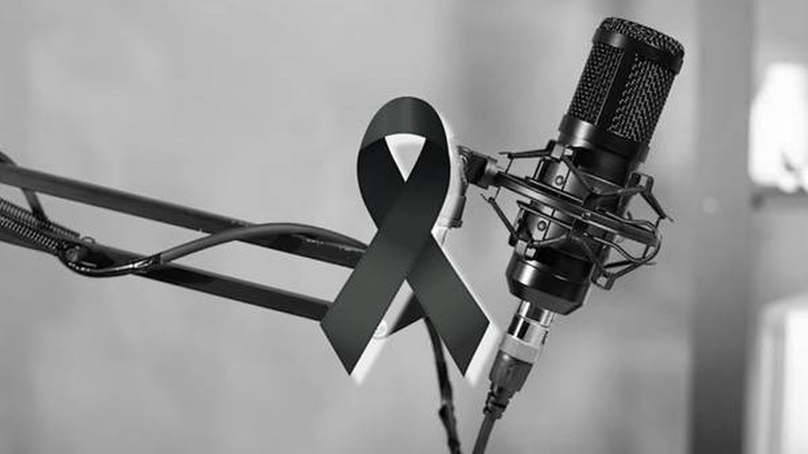 Microfone de rádio profissional com fita preta de luto em preto e branco