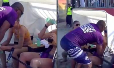 Homem de camisa roxa agride atletas sentadas em quadra de vôlei de praia