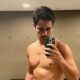 Danilo Mesquita, sem camisa, tira selfie no espelho com smartphone verde