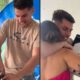 Homem sorridente com confete, abraçando mulher e segurando caixa de PlayStation 5