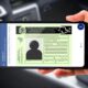 Mão segura celular exibindo CNH Digital brasileira com fundo de carro embaçado