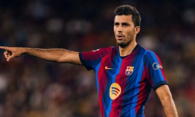 Rodri, jogador do Barcelona com camisa listrada, apontando com o braço estendido