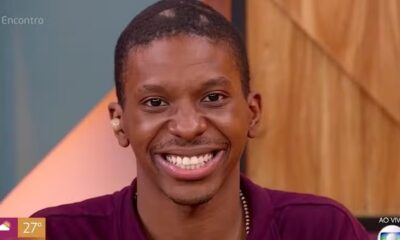 Jovem negro sorrindo em tela de TV, com # Encontro e AO VIVO na tela