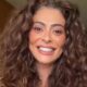Rosto de Juliana Paes em close-up, sorrindo com cabelo cacheado castanho