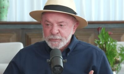 O presidente Lula da Silva, usando um chapéu de palha, barba grisalha, camisa azul, fala ao microfone