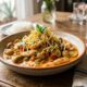 Prato de strogonoff com frango, cogumelos, batata palha, salsa, arroz, água e talheres em mesa