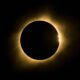 Eclipse solar total com disco escuro, halo luminoso e um ponto de luz brilhante