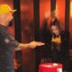 Homem de boné amarelo entrega fatia de bolo vermelho "30" com tema Homem-Aranha a mulher