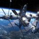 Estação espacial complexa com ônibus espacial acoplado orbitando a Terra com estrelas ao fundo