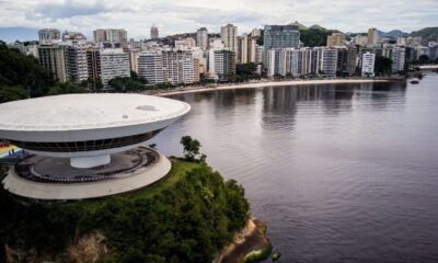 Museu de Arte Contemporânea de Niterói e cidade costeira sob céu nublado