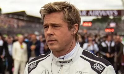 Brad Pitt, cabelo loiro, em uniforme de corrida branco, com fone de ouvido