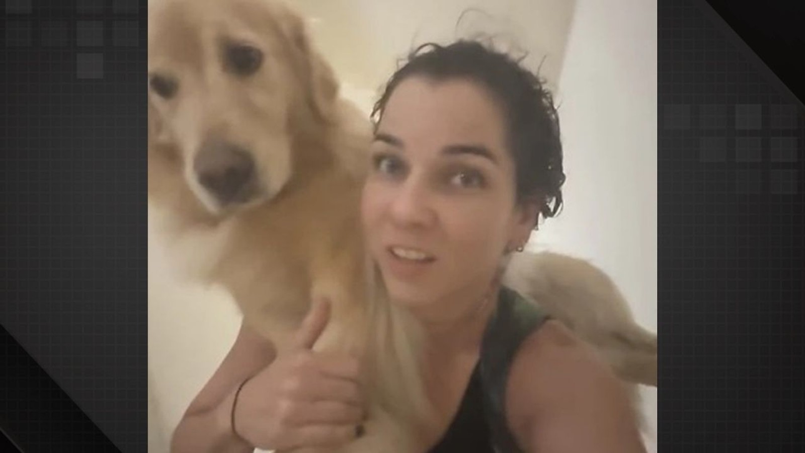 Mulher de cabelos escuros e molhados carregando um golden retriever nos ombros olhando para a câmera