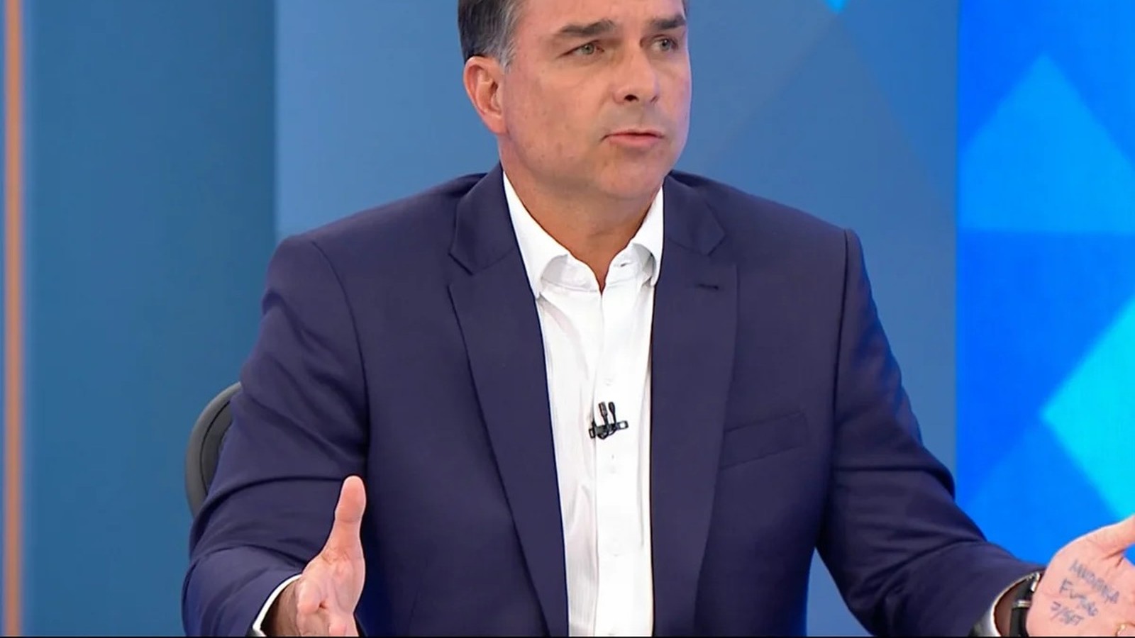 Homem de terno e camisa branca, com anotações "MUDANÇA FUTURO 7/SET" na mão