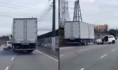 Caminhão branco e carro branco danificado na estrada, portas abertas