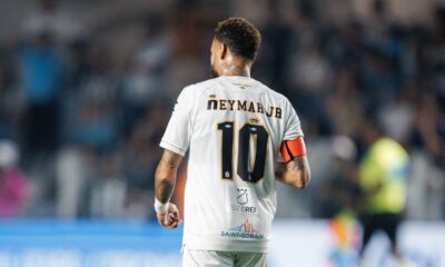 Neymar Jr de costas com camisa 10 branca do Santos e braçadeira de capitão laranja